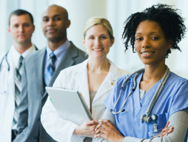 Four medical professionals of multiple disciplines smiling and looking at the camera