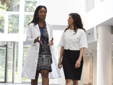 Two women medical professionals walking and talking