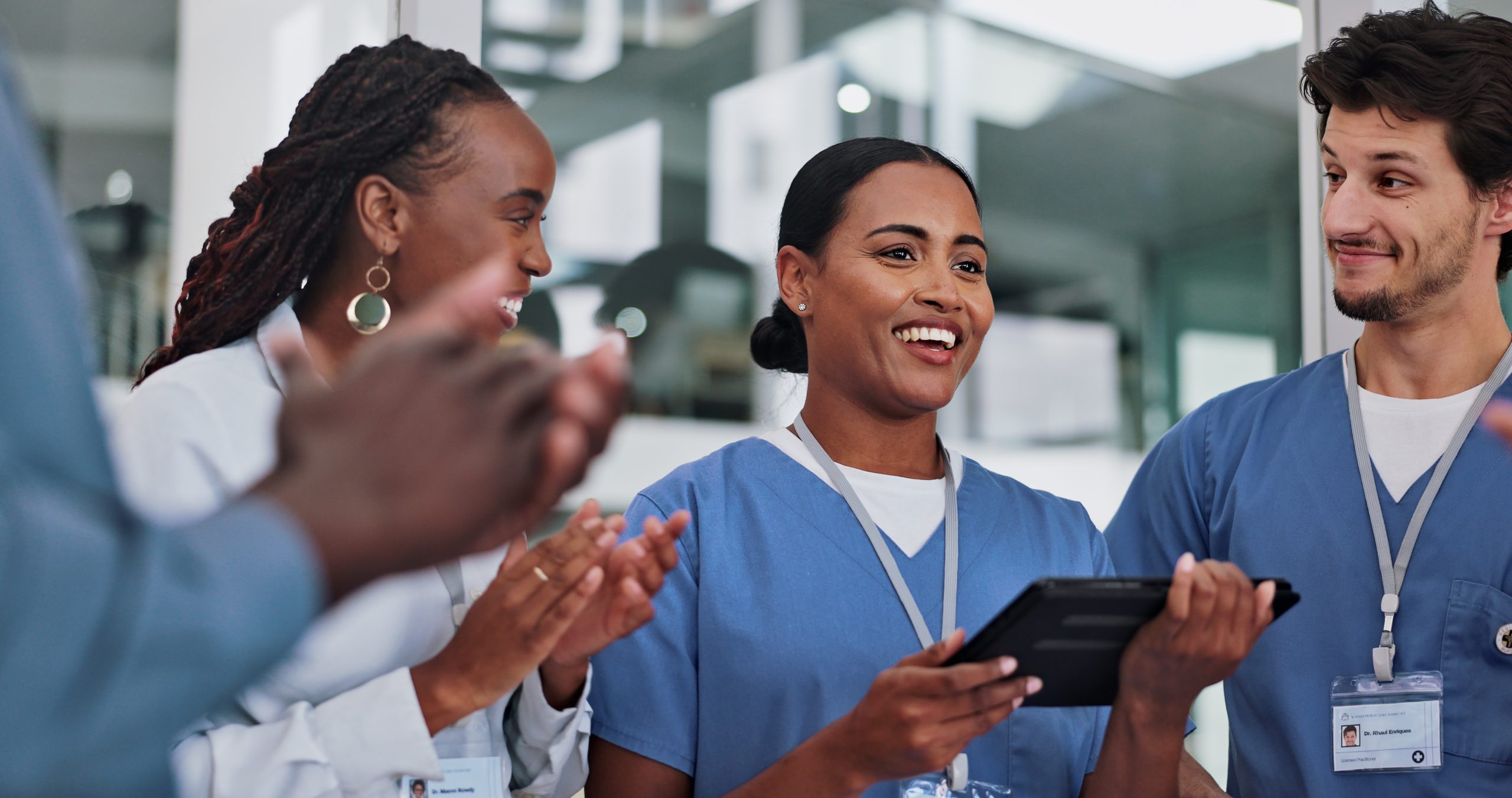 Resident smiling while other medical professionals smile and applaud