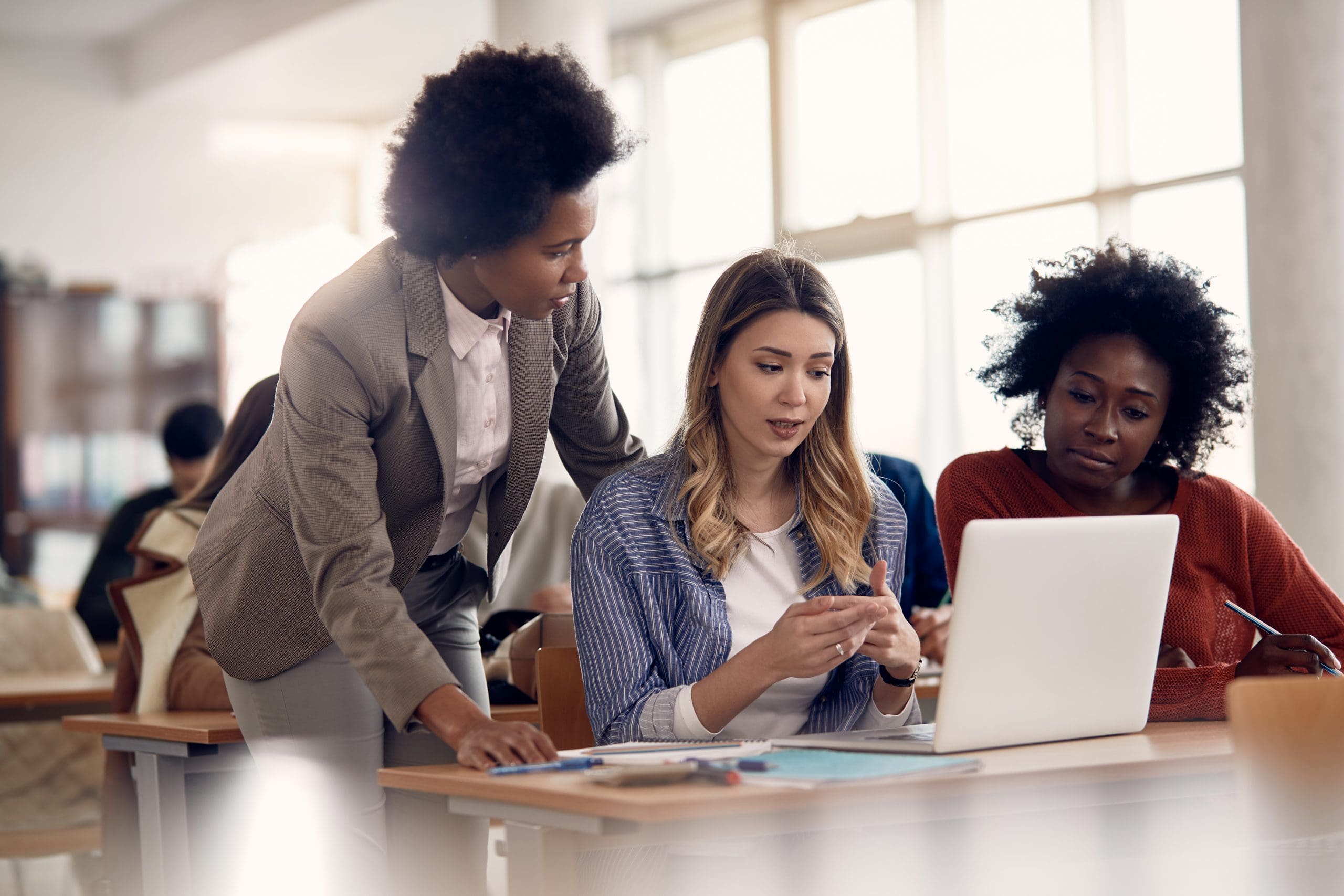 Female,Students,Communicating,With,Their,Teacher,While,Using,Computer,During