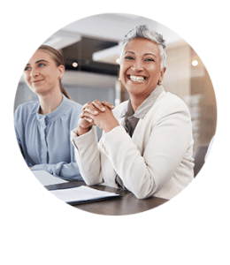 older black female smiling while seated at boardroom table